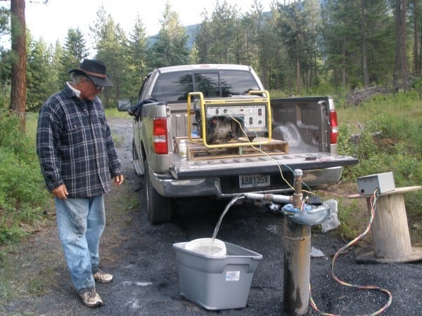 man standing with generator on a pickup truck