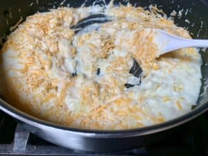 adding cheese to pan on stovetop when making au gratin potatoes